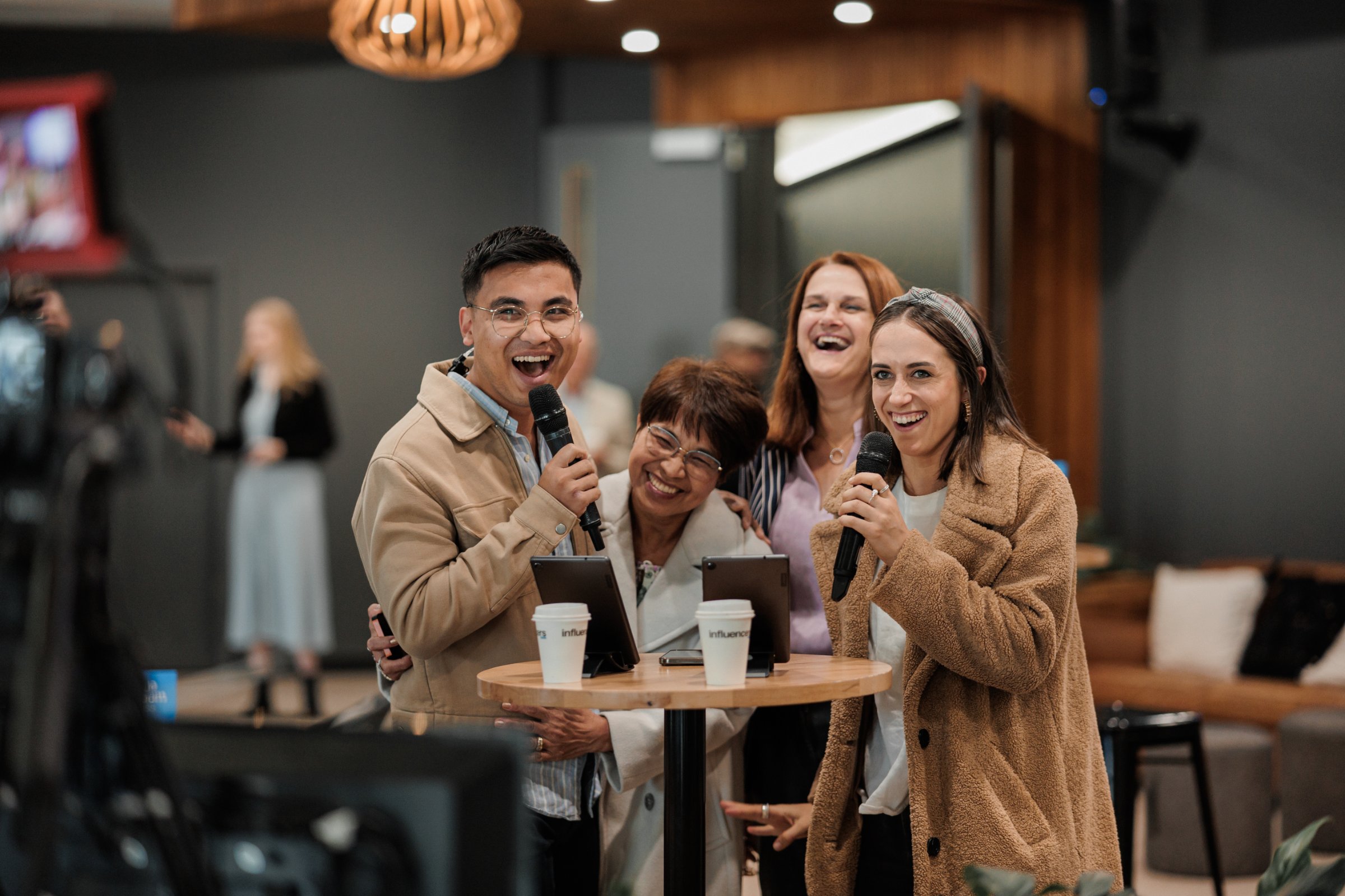 Paradise — four friends mid-laugh in the lobby, cross-generational warmth